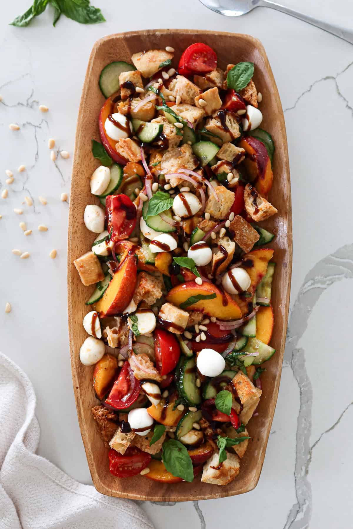 Peach panzanella salad in serving dish.