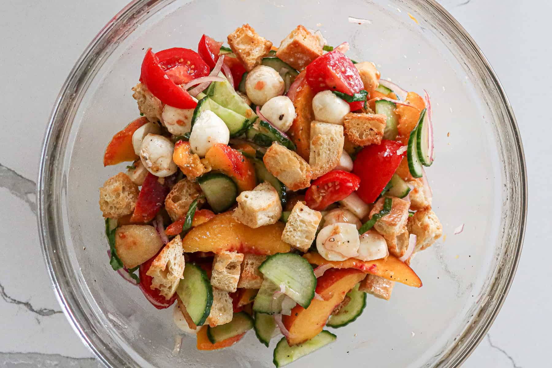 Toasted bread cubes added to salad, everything mixed together.