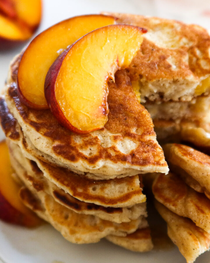 Peach pancakes on a white serving plate.
