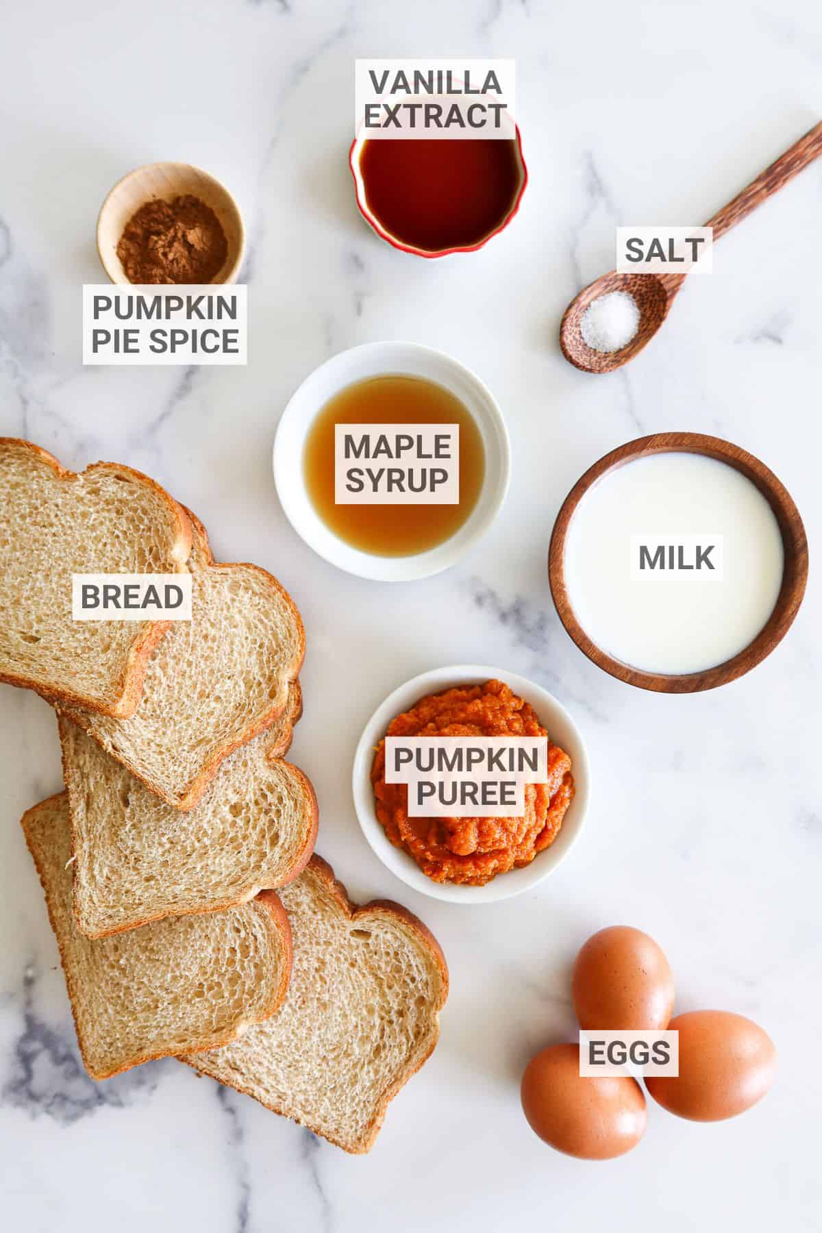 Pumpkin french toast ingredients on a white countertop with text overlay labels.