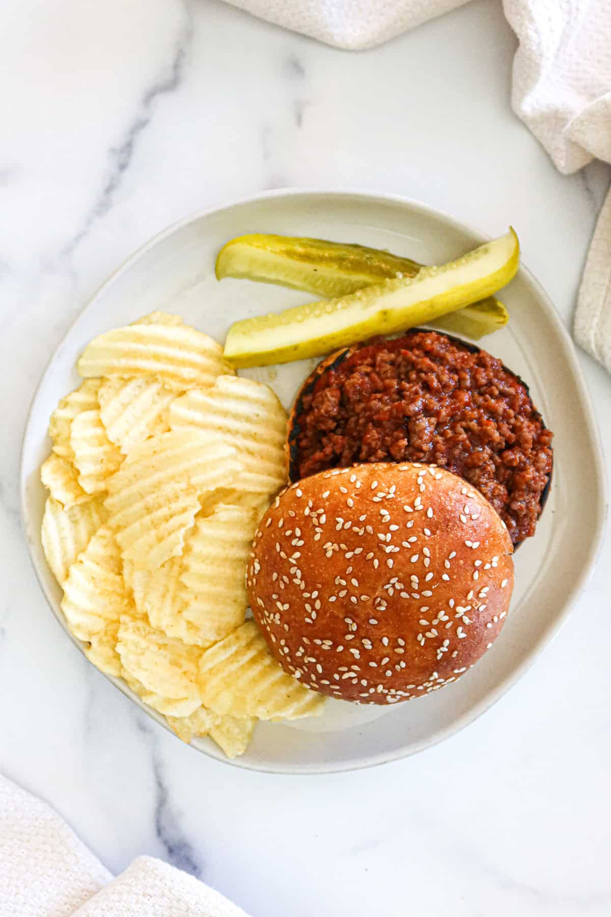 Sloppy joe with chips and pickles.