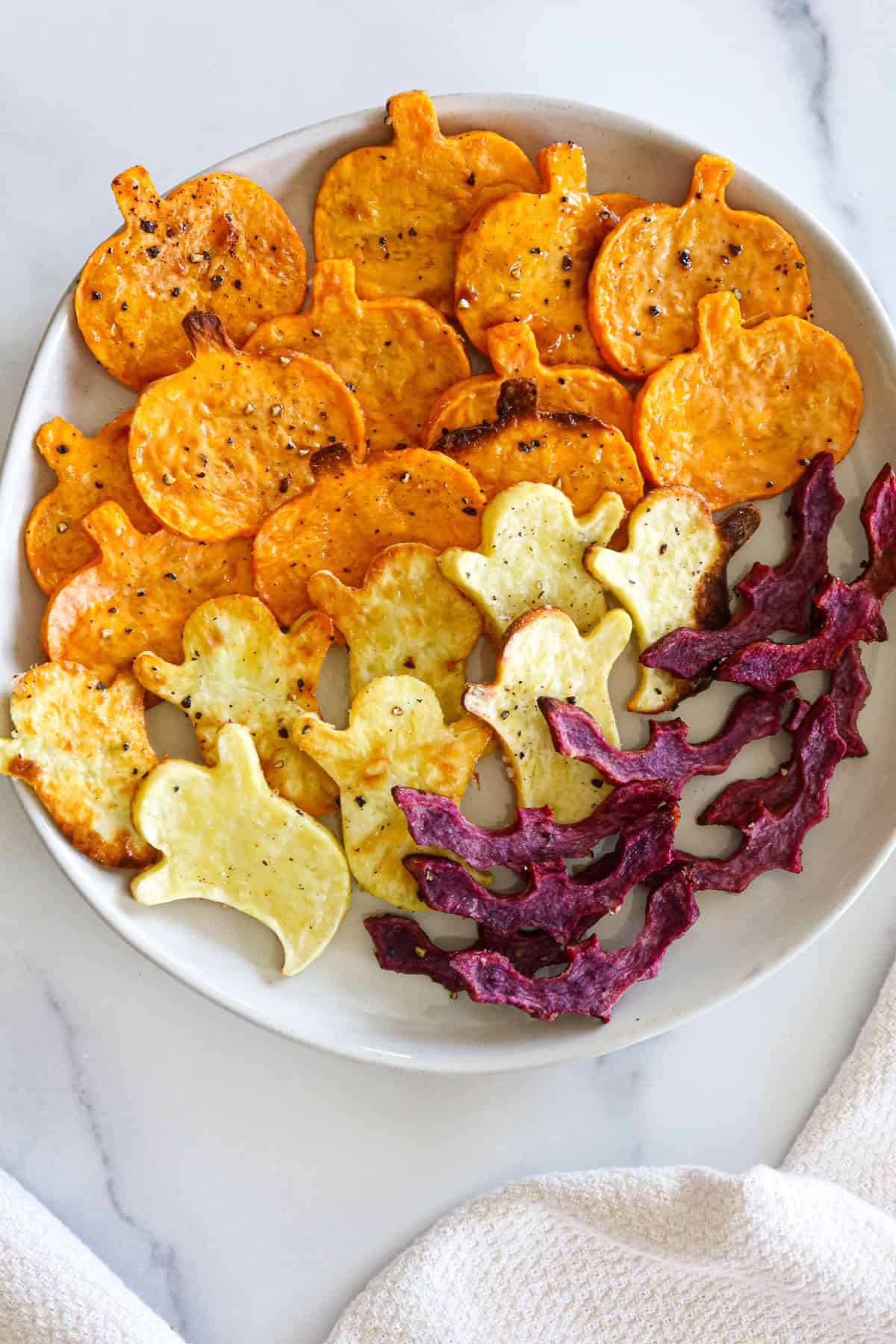 Roasted spooky sweet potatoes on a white plate.