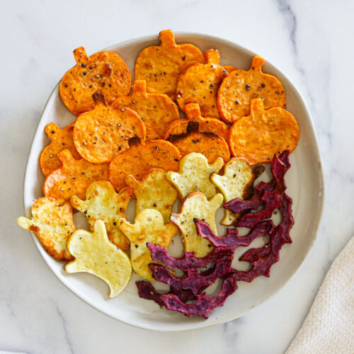 Spooky roasted sweet potatoes on a white plate.