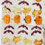 Roasted spooky sweet potatoes on a baking sheet with text overlay for Pinterest.