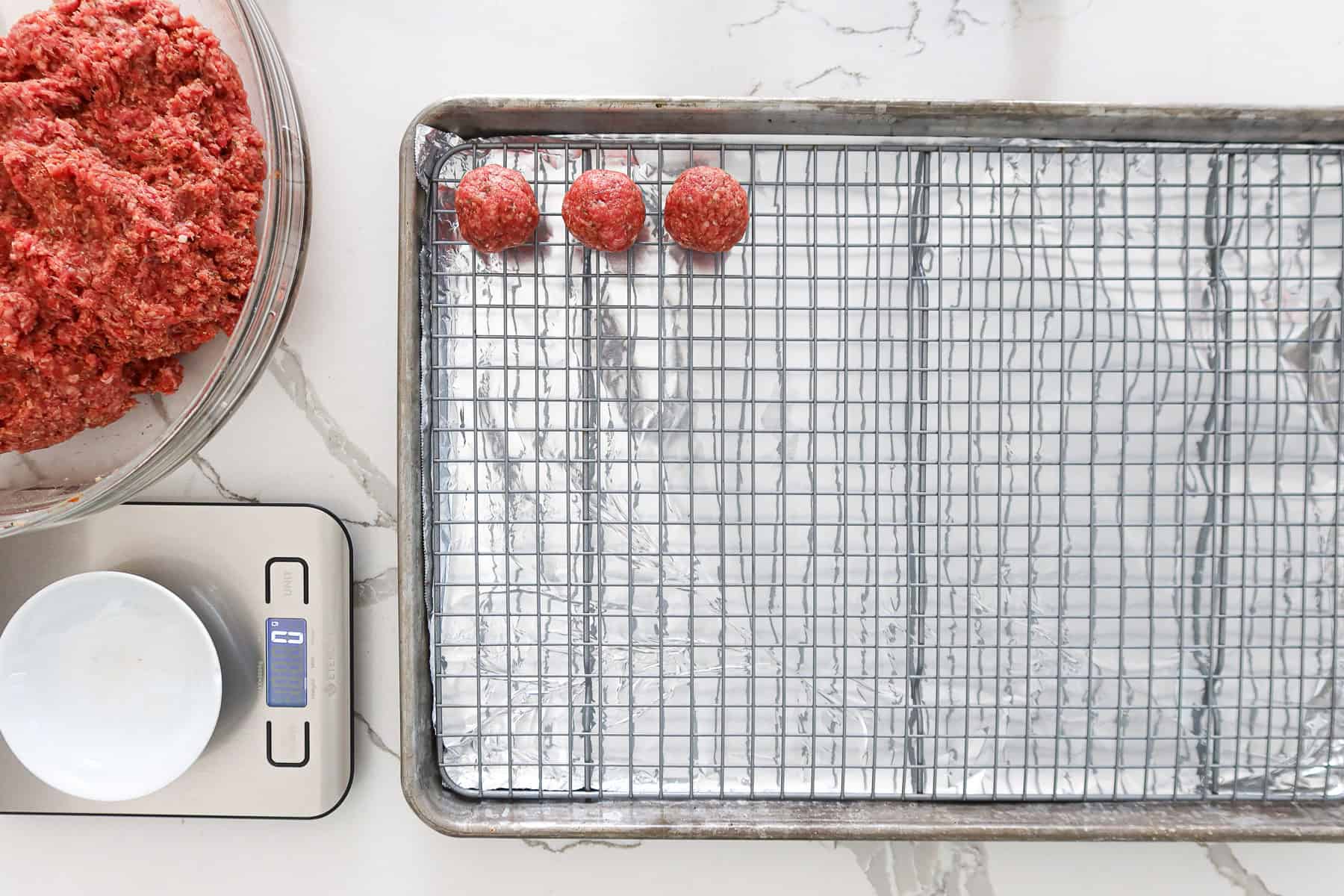 Rolling ground beef mixture into meatballs.