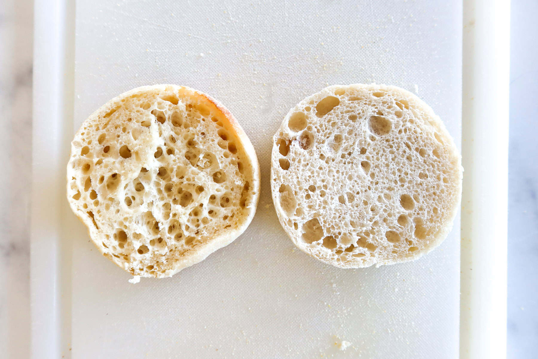Two different brands of english muffins, cut side up to show differences in pore size.