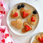 Heart shaped pancakes with berries on top.