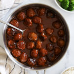 Sweet and sour meatballs in a stainless skillet.
