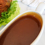 Ham gravy in a white gravy boat.