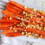 Roasted honey feta carrots on a white serving plate.