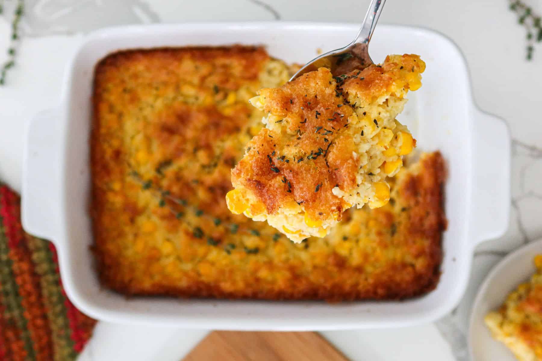Corn casserole in a white baking dish.