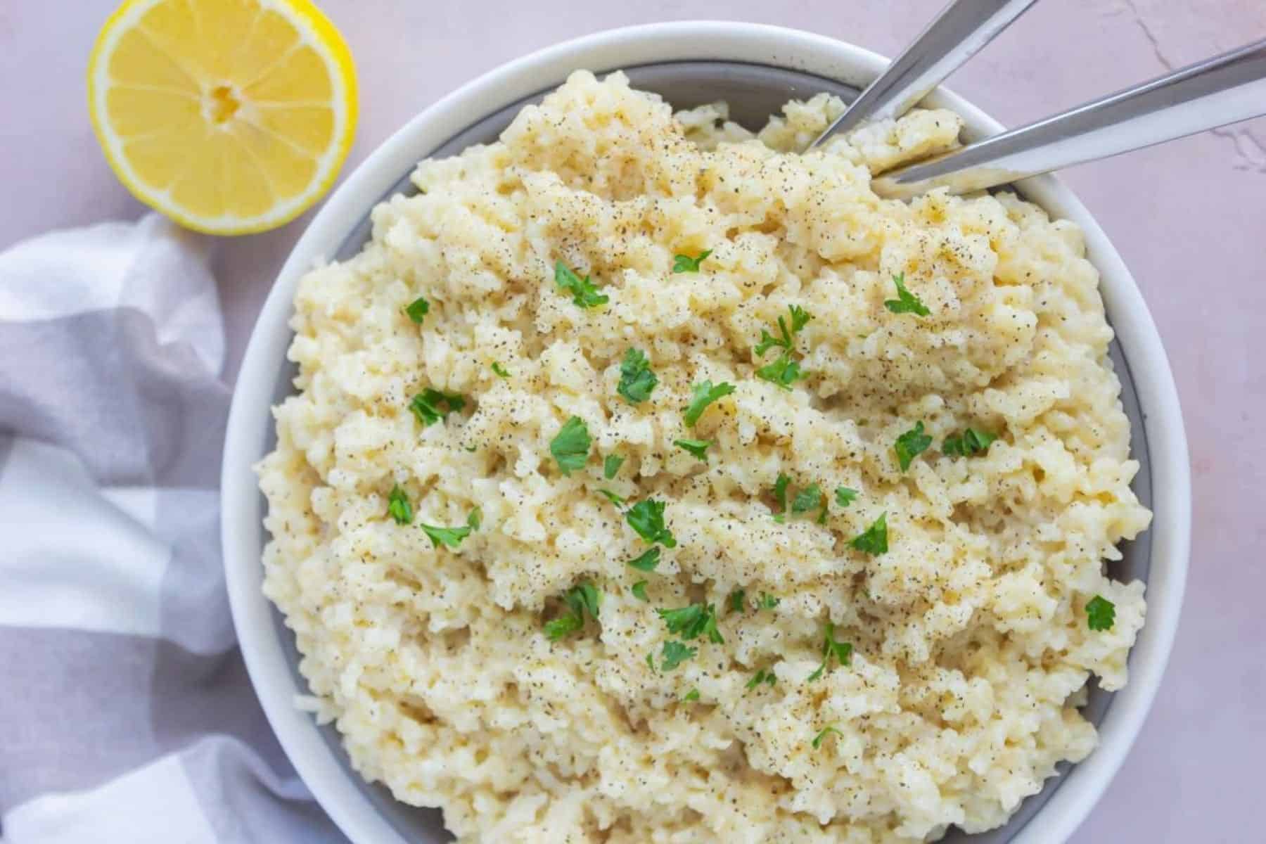 Creamy parmesan rice in a white serving dish.
