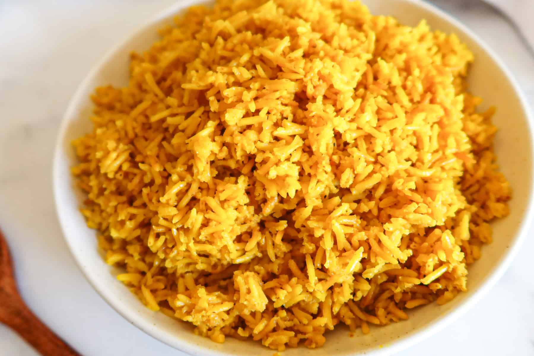 Yellow rice in a white serving dish.