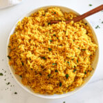 Yellow rice in a white serving dish.