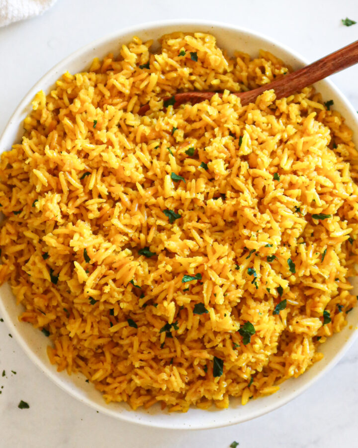 Yellow rice in a white serving dish.