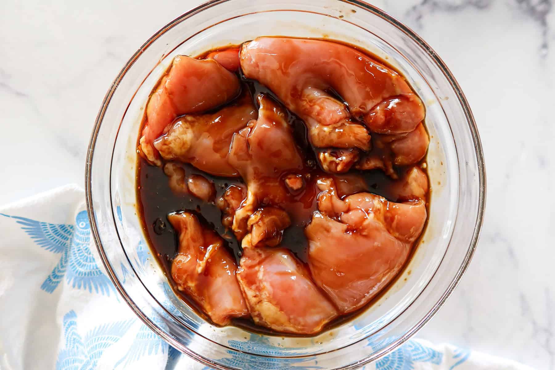Chicken thighs marinating in teriyaki sauce.