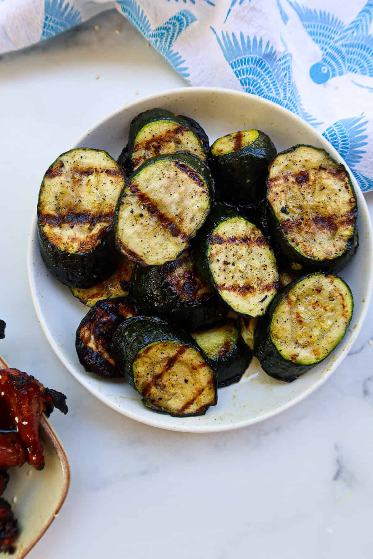 Grilled zucchini on a white plate.