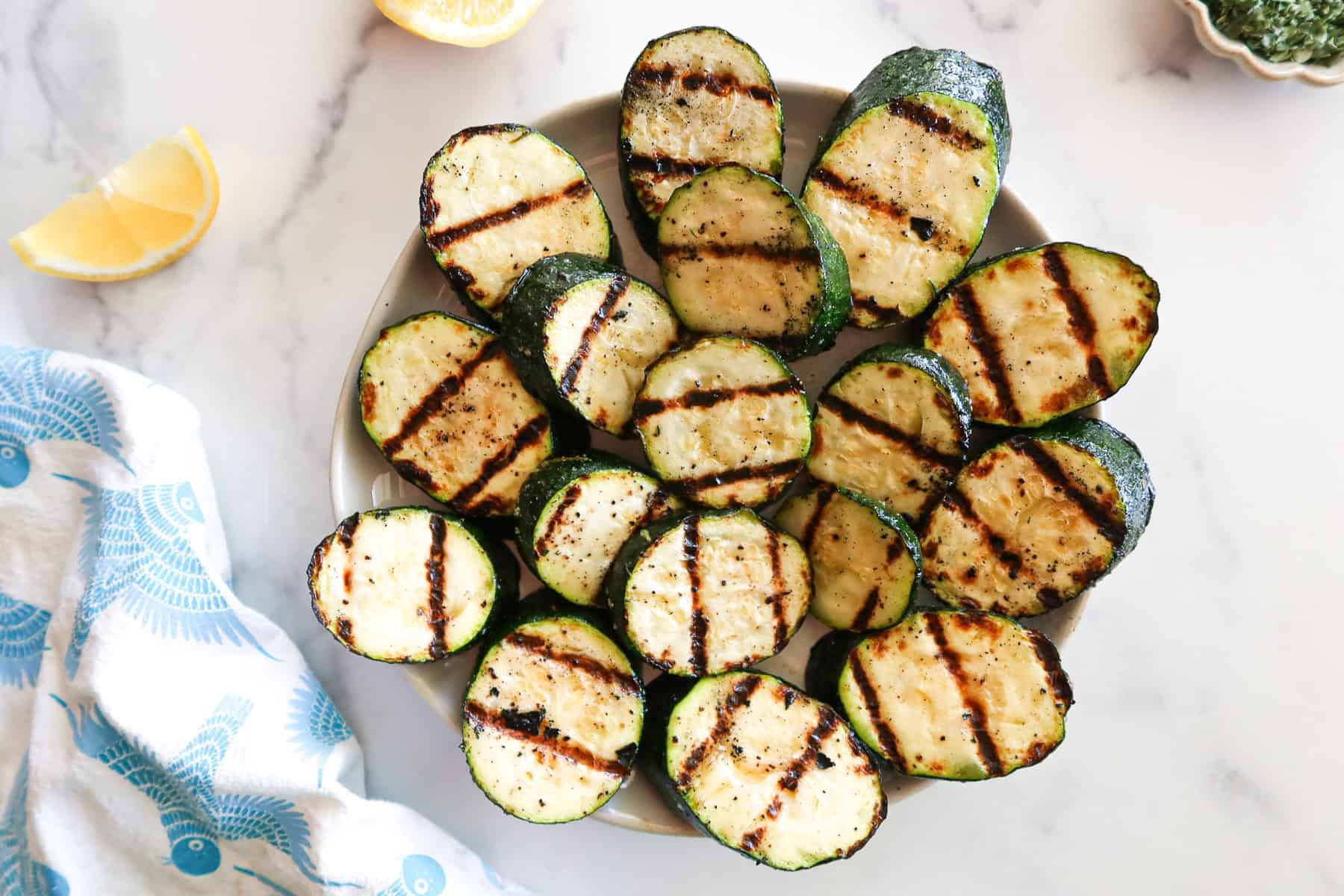 Grilled zucchini on a white serving platter.
