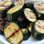 Grilled zucchini on a white plate.