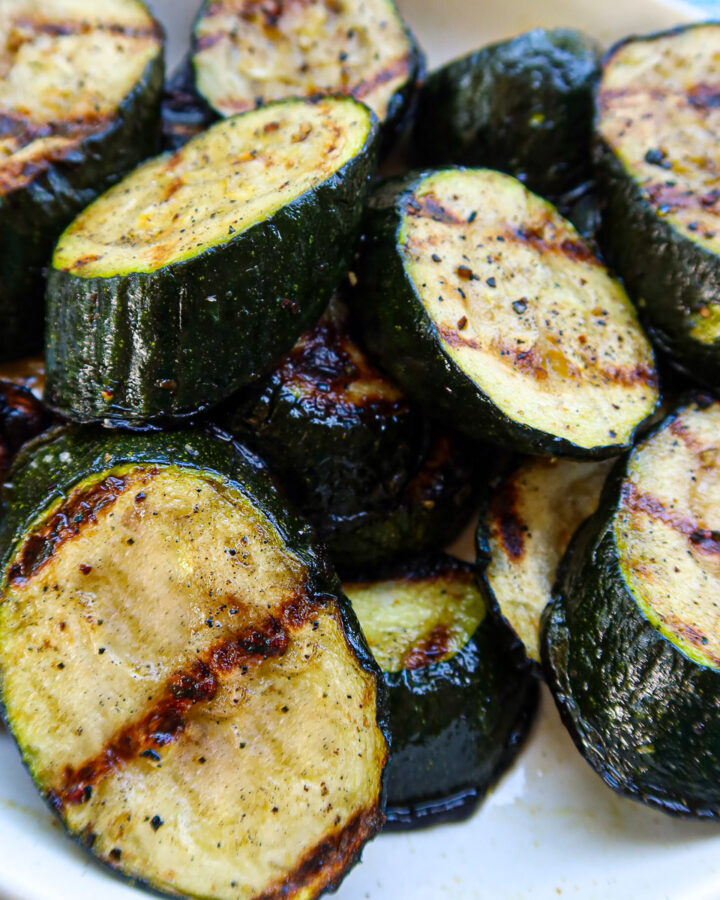 Grilled zucchini on a white plate.
