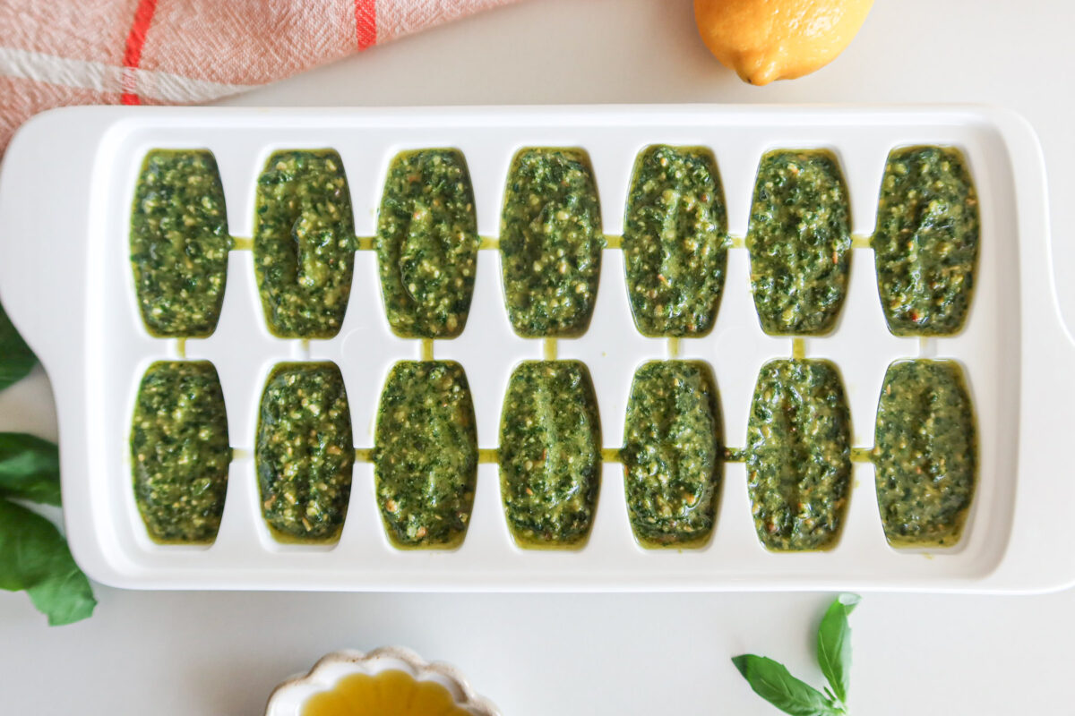 Pesto portioned into an ice cube tray for freezing.