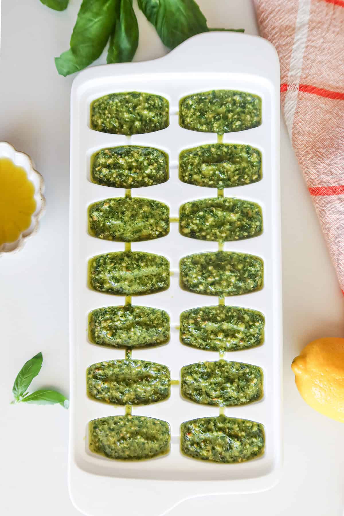 Pesto portioned into an ice cube tray for freezing.