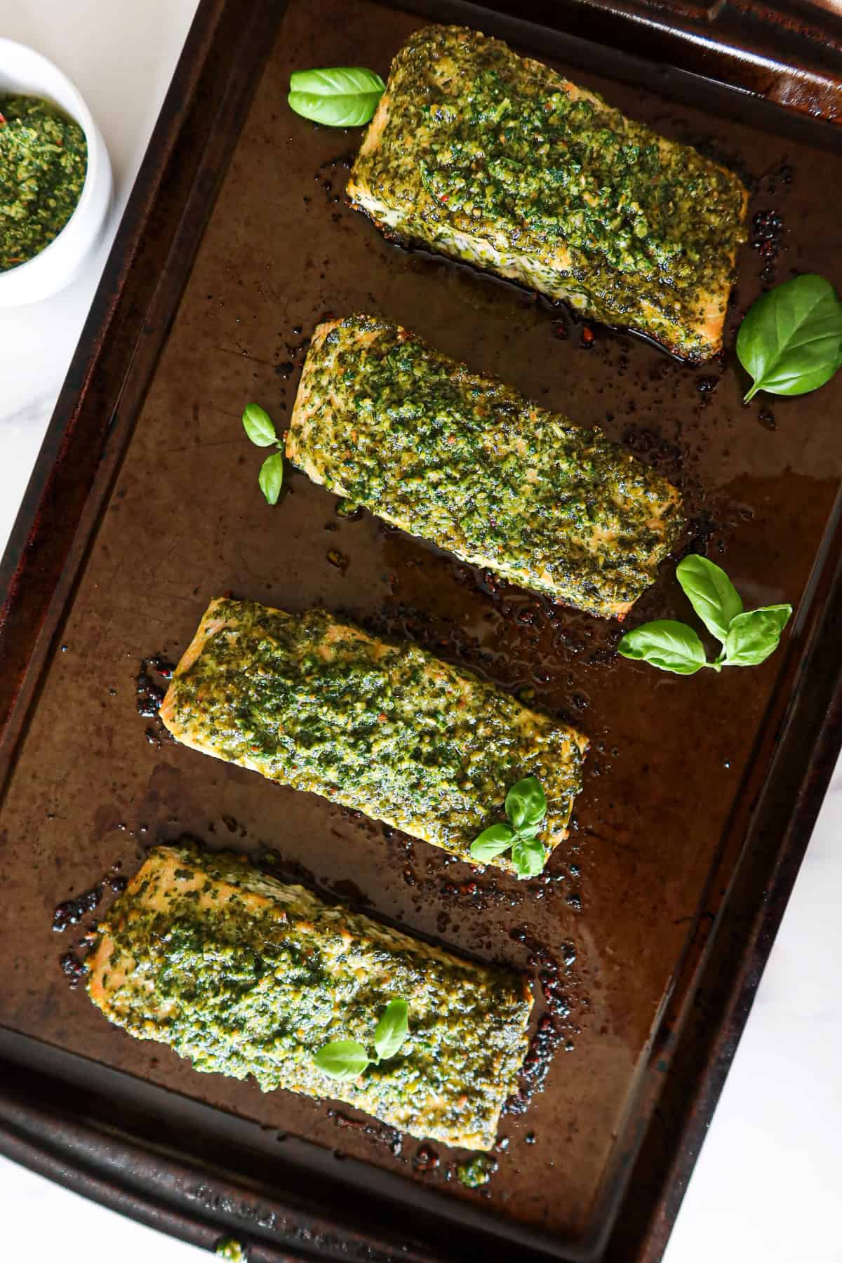 Pesto salmon on a baking sheet.