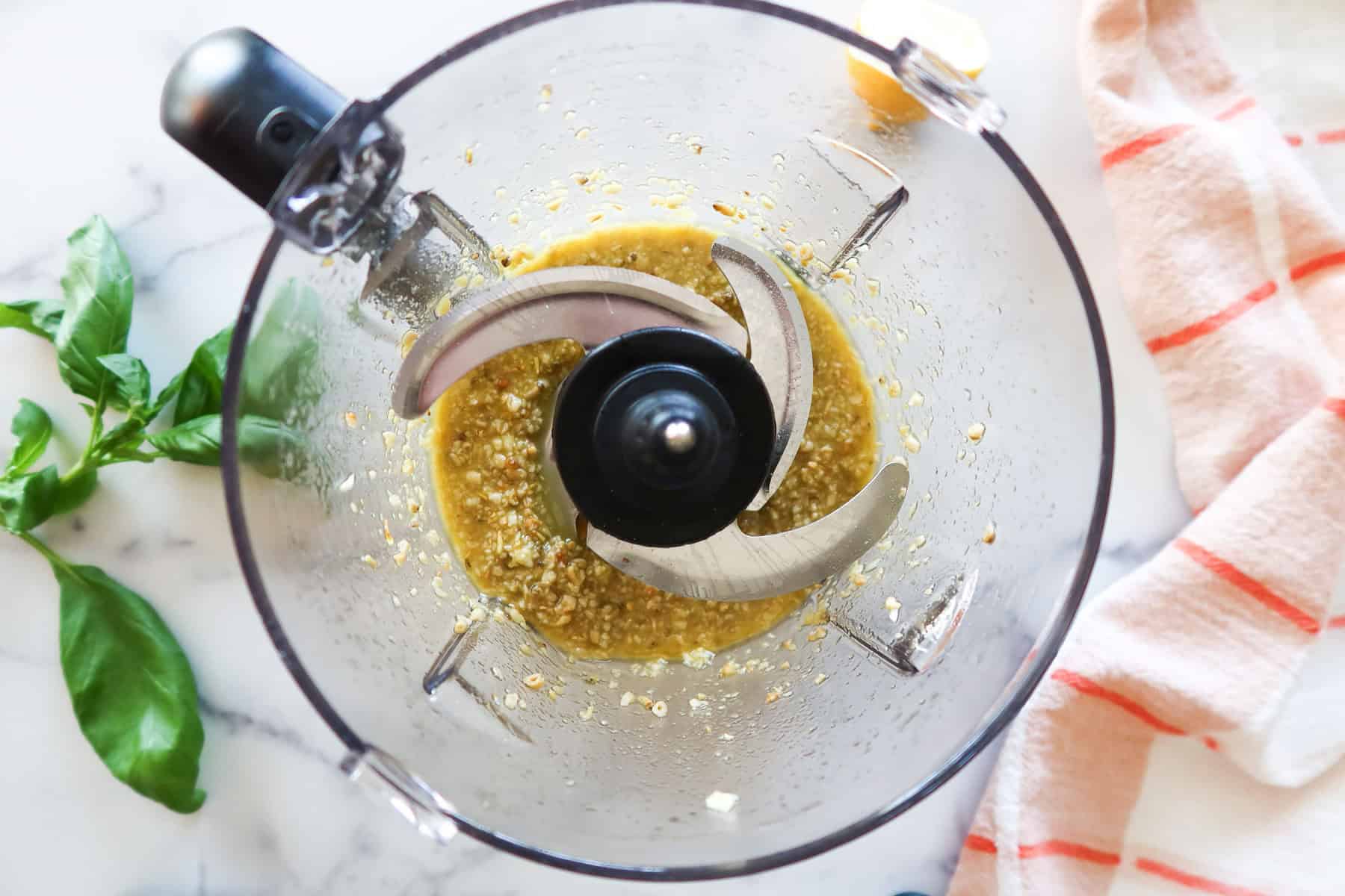 Puréed pine nuts, garlic and olive oil in food processor.