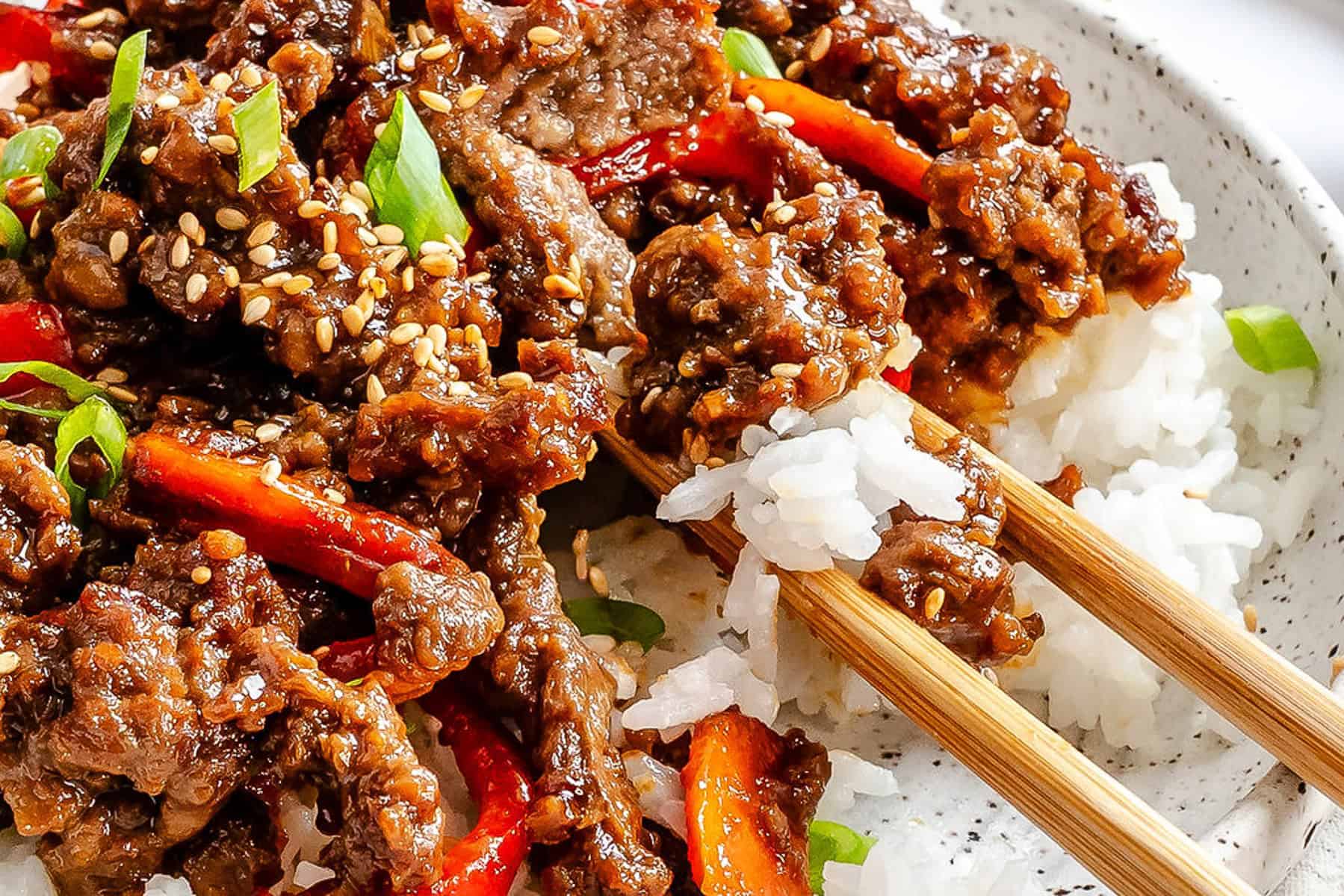 Asian beef bowl with garlic salt and lime, served with rice and vegetables.