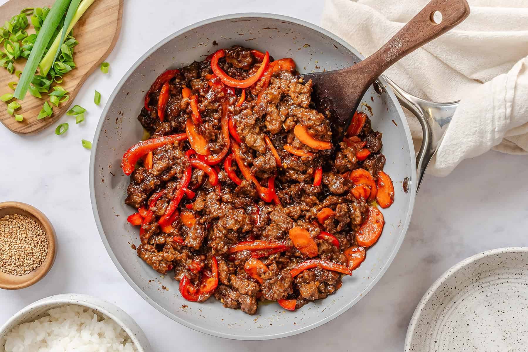 Teriyaki sauce mixed into the skillet with ground beef and veggies.