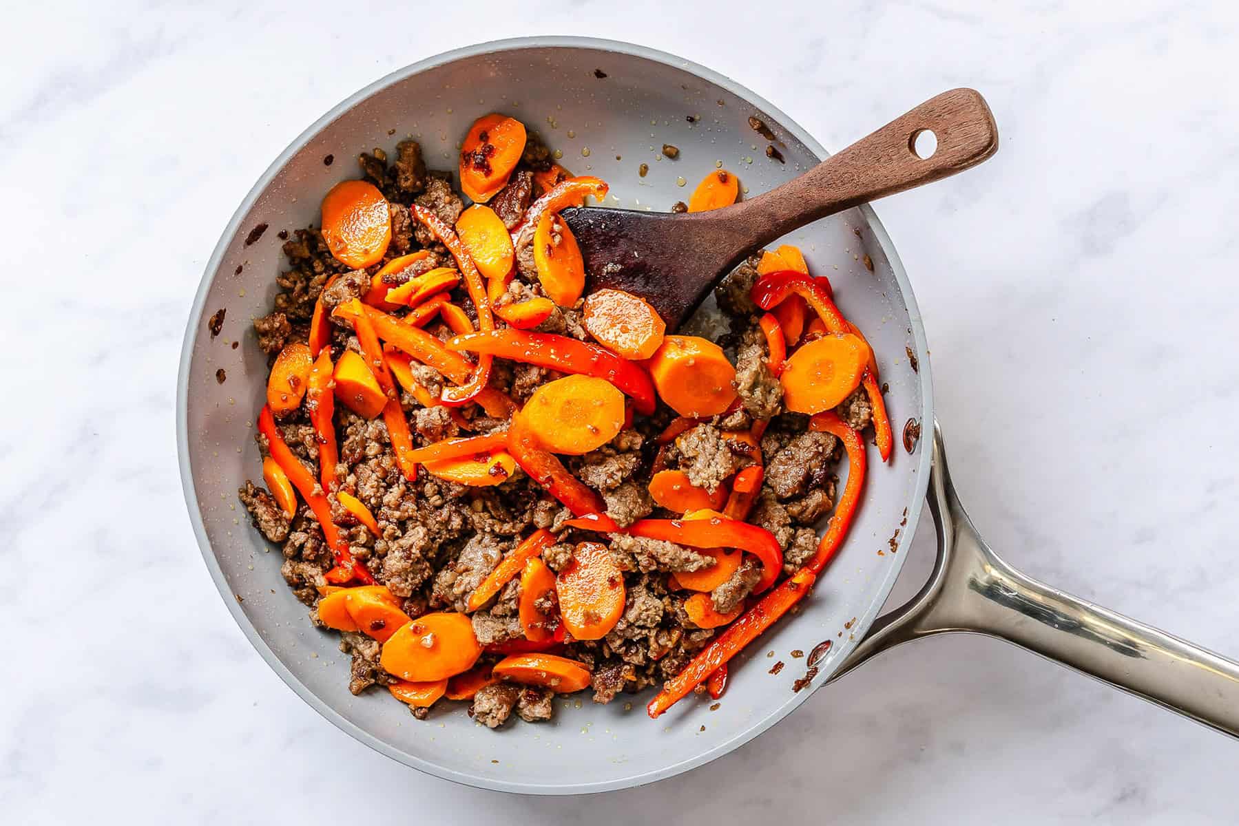 Browned ground beef and veggies in a skillet.