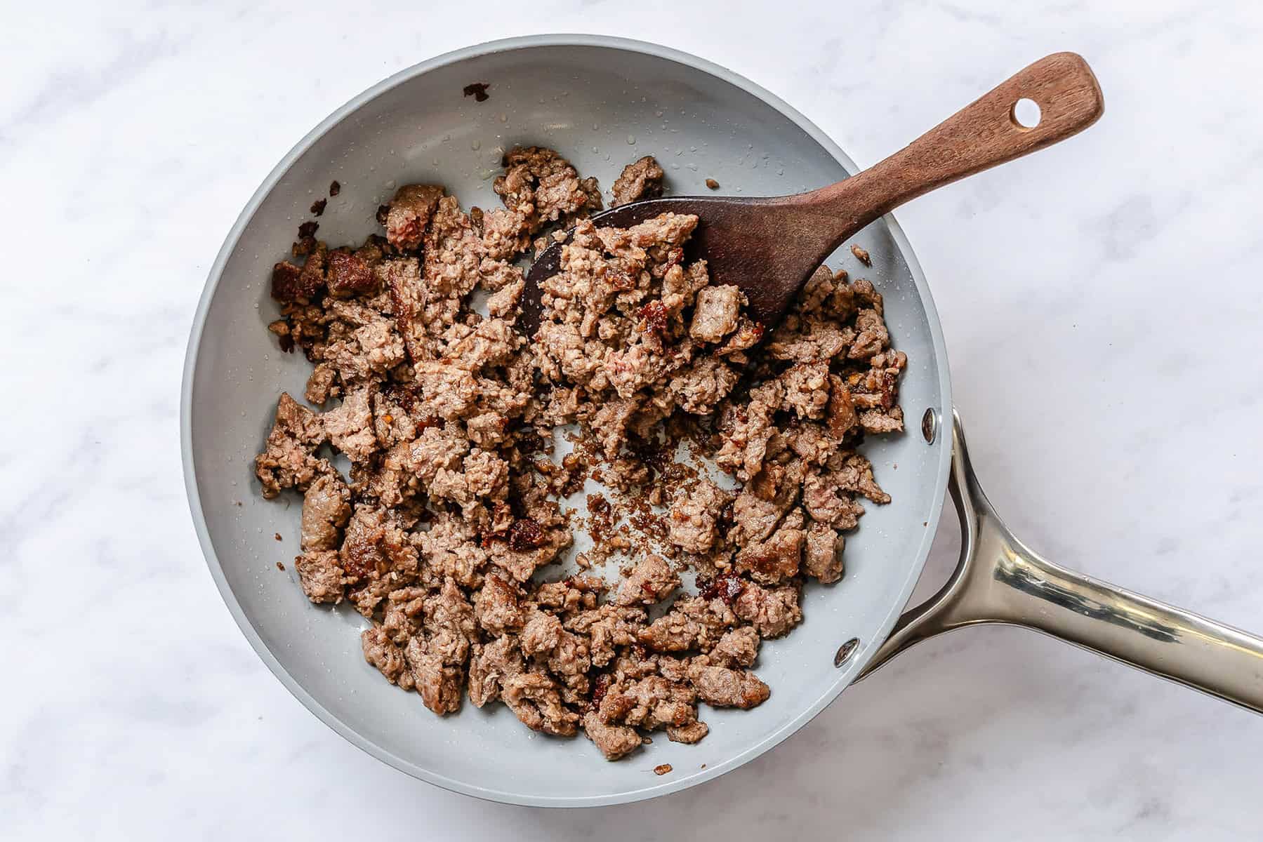 Ground beef browned in a skillet.